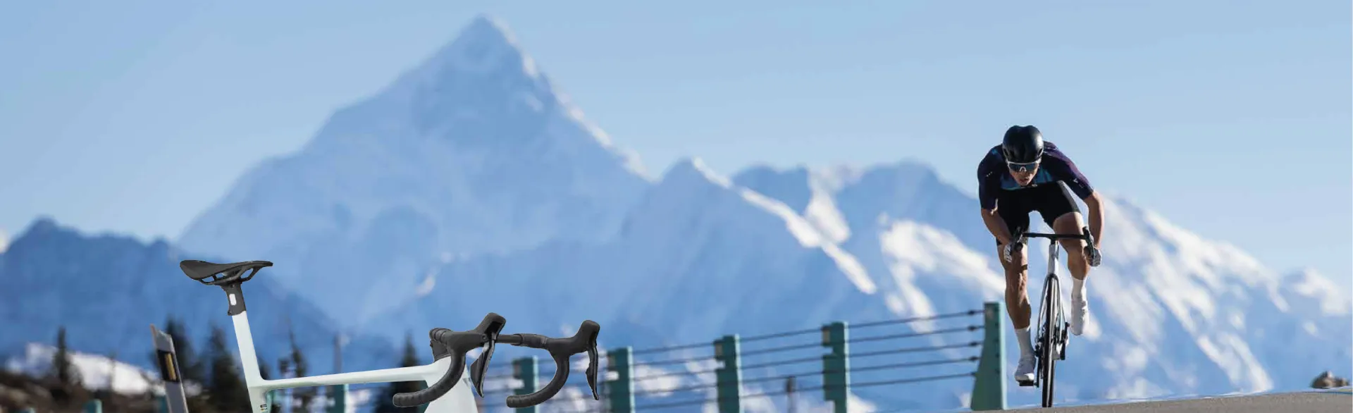 Cycliste sur route devant un paysage de montagne, illustrant l’amélioration de l’endurance à vélo pour les longues sorties.