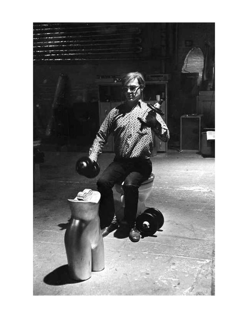 Arnold Andy WARHOL, exercising seated on the toilet, in the Silver Factory, New York. 1964 by Eve Arnold