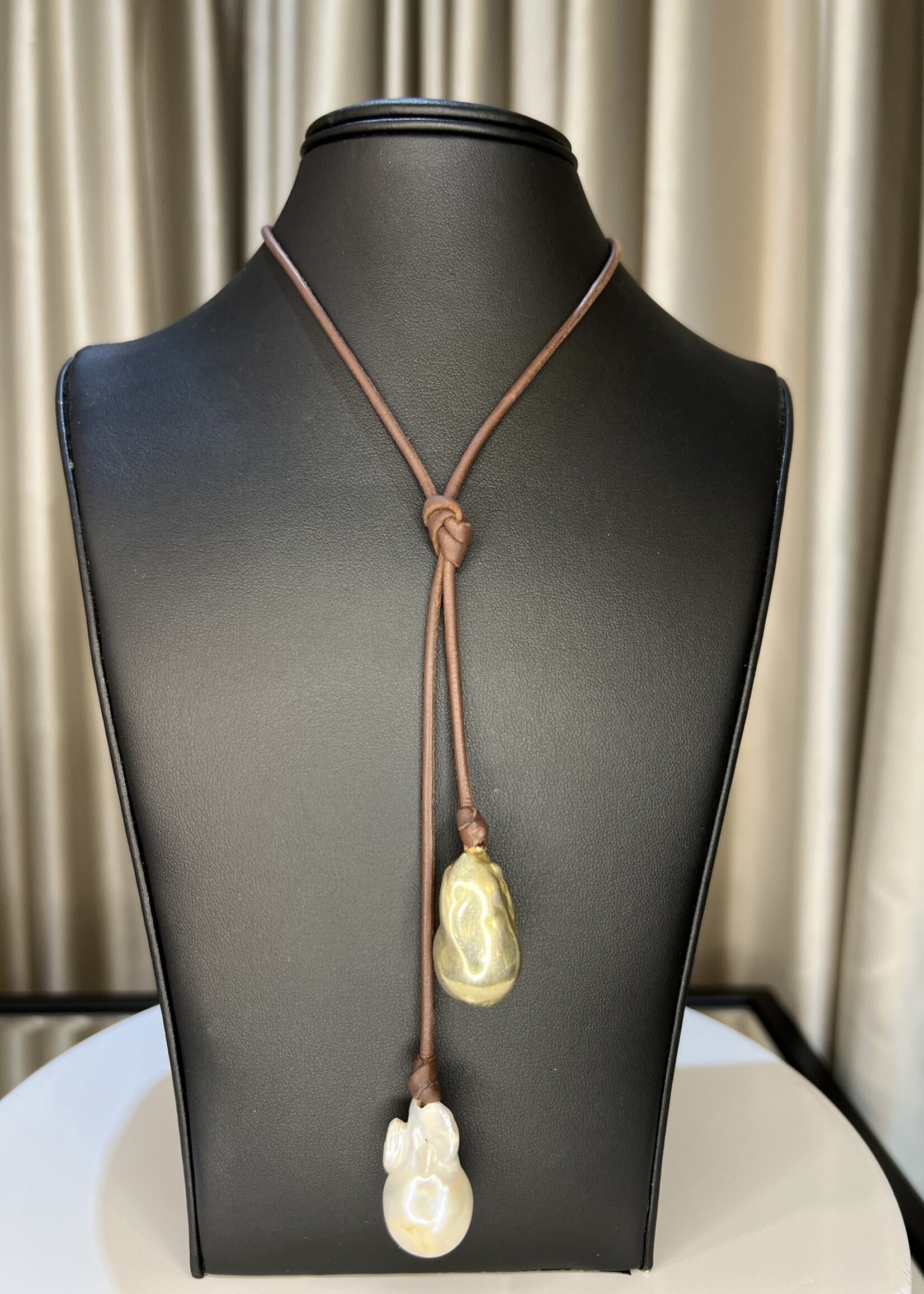 Mina Danielle Large white Baroque Pearl with Gold Bead hang from each end of chocolate brown leather cord. Can be worn multiple ways
