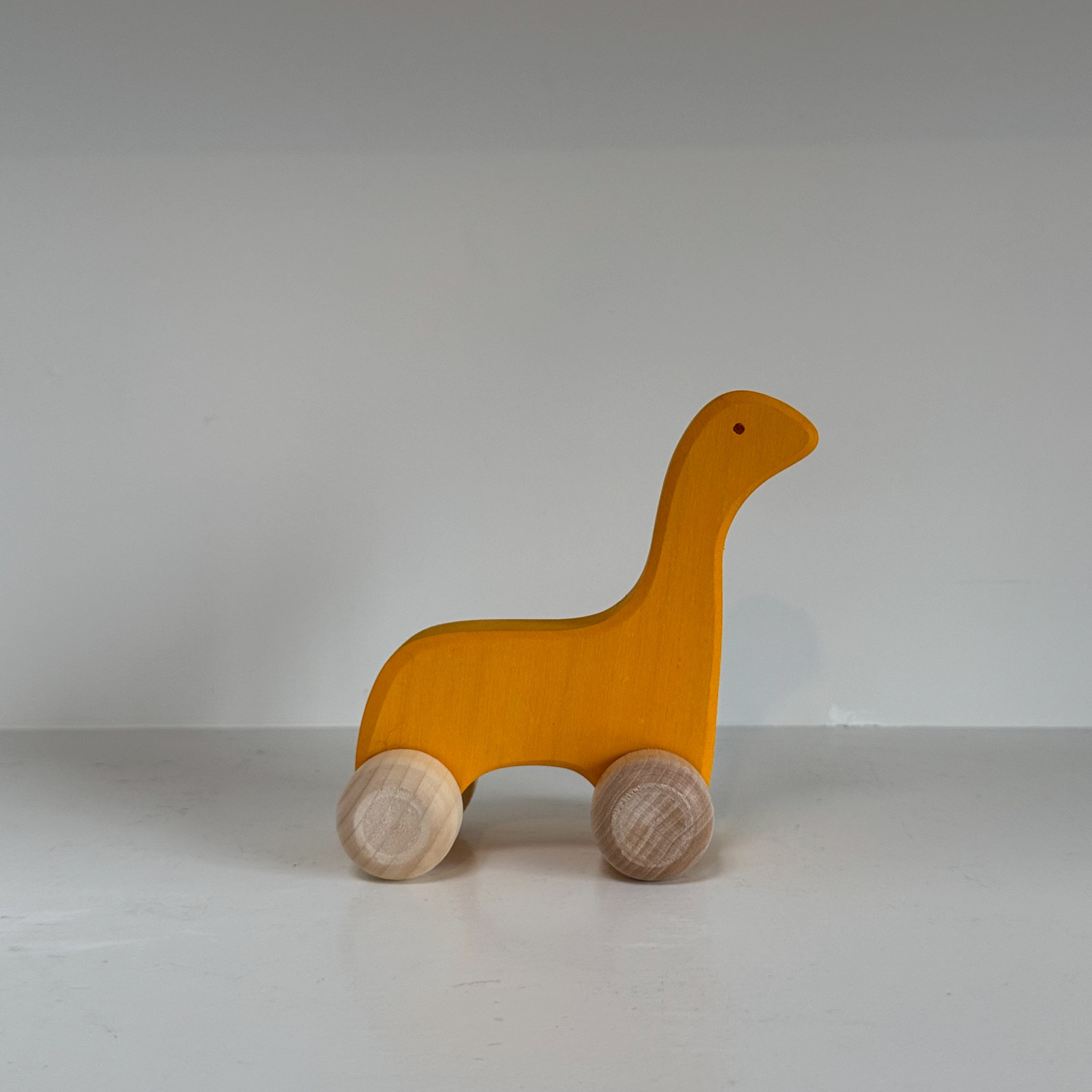 Abstract Wooden Yellow Dinosaur Friend on Wheels