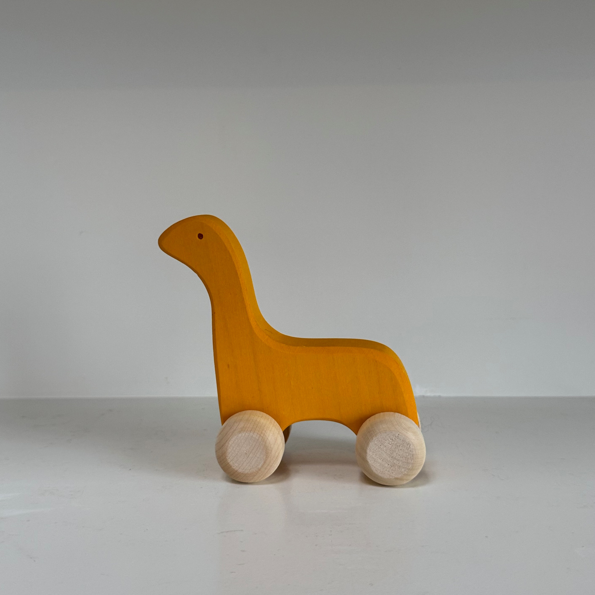 Abstract Wooden Yellow Dinosaur Friend on Wheels