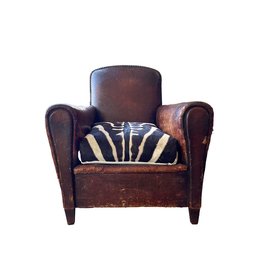 Brown leather chair with zebra hide cushion