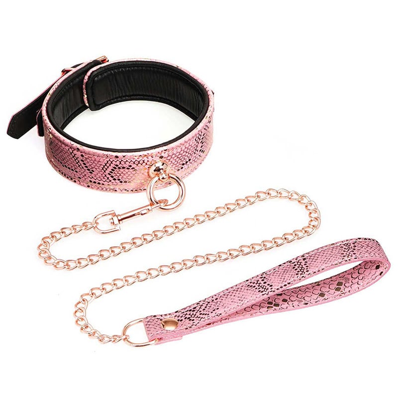 A pink collar and leash set against a white background. The leash and collars have snakeskin print and collar has a round ring in the front with a leash attached to it. The metal is a rose gold color. The back of the collar has a metal buckle to adjust the size.