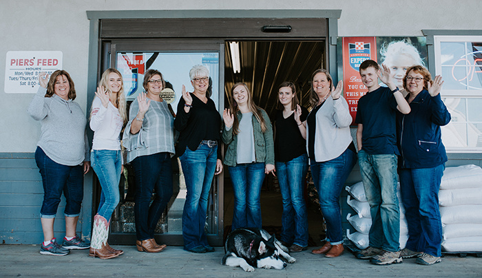 Piers Feed team members standing on their porch waiving