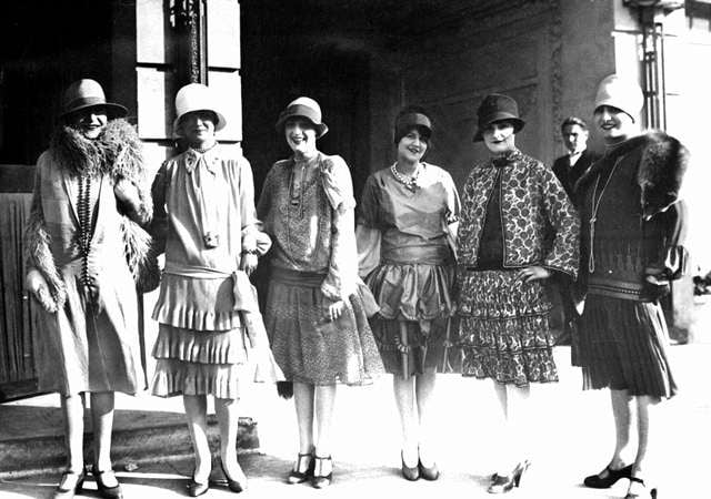 woman in group in the twenties wearing beautiful dresses and cloche hats