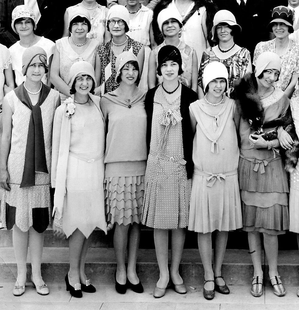 groupe de femmes dans les années 1920 portant de jolies robes et des chapeaux cloche