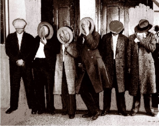 Photo ancienne du gang des Belltone Dads se couvrant le visage avec leurs chapeaux