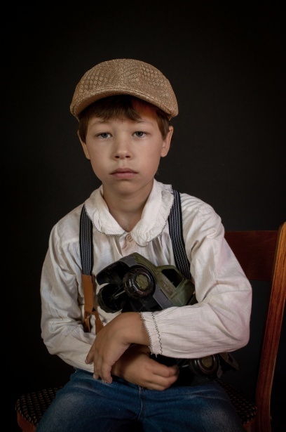 Boy holding a toy truck and wearing a duckbill cap