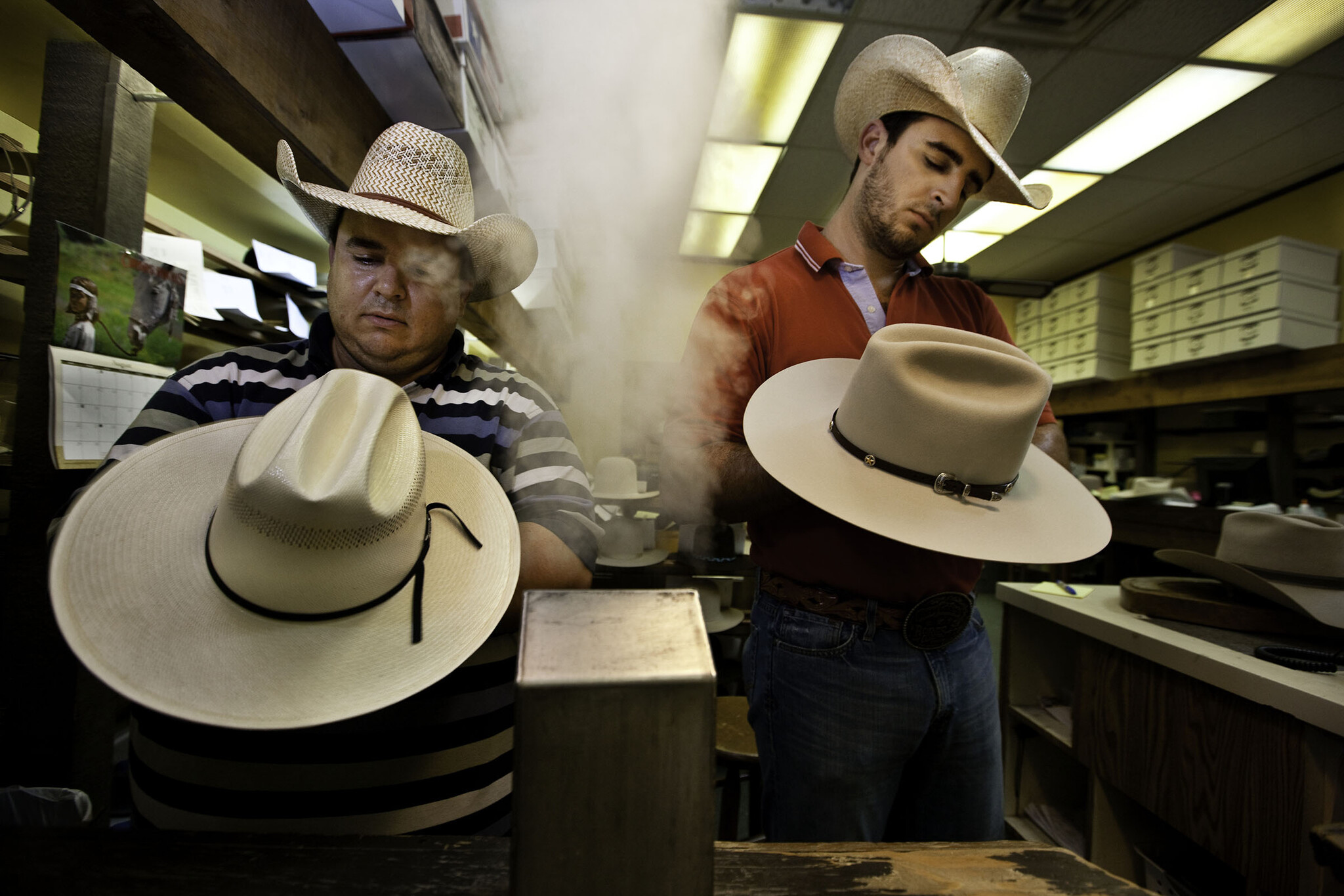 Chapeliers travaillant à la finitions de chapeaux de cowboy