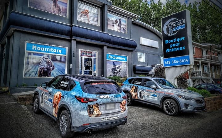 Deux véhicules de livraison La Niche à Luna garés devant la boutique de Sainte-Marie