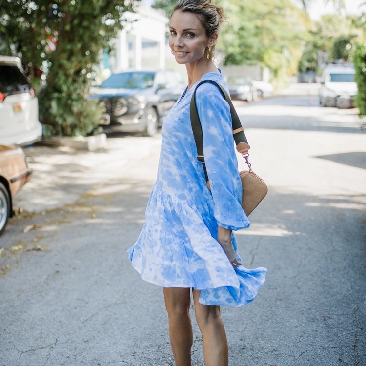 young woman outside wearing a blue and white dress