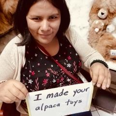 woman with sign that reads 'I made your alpaca toys'