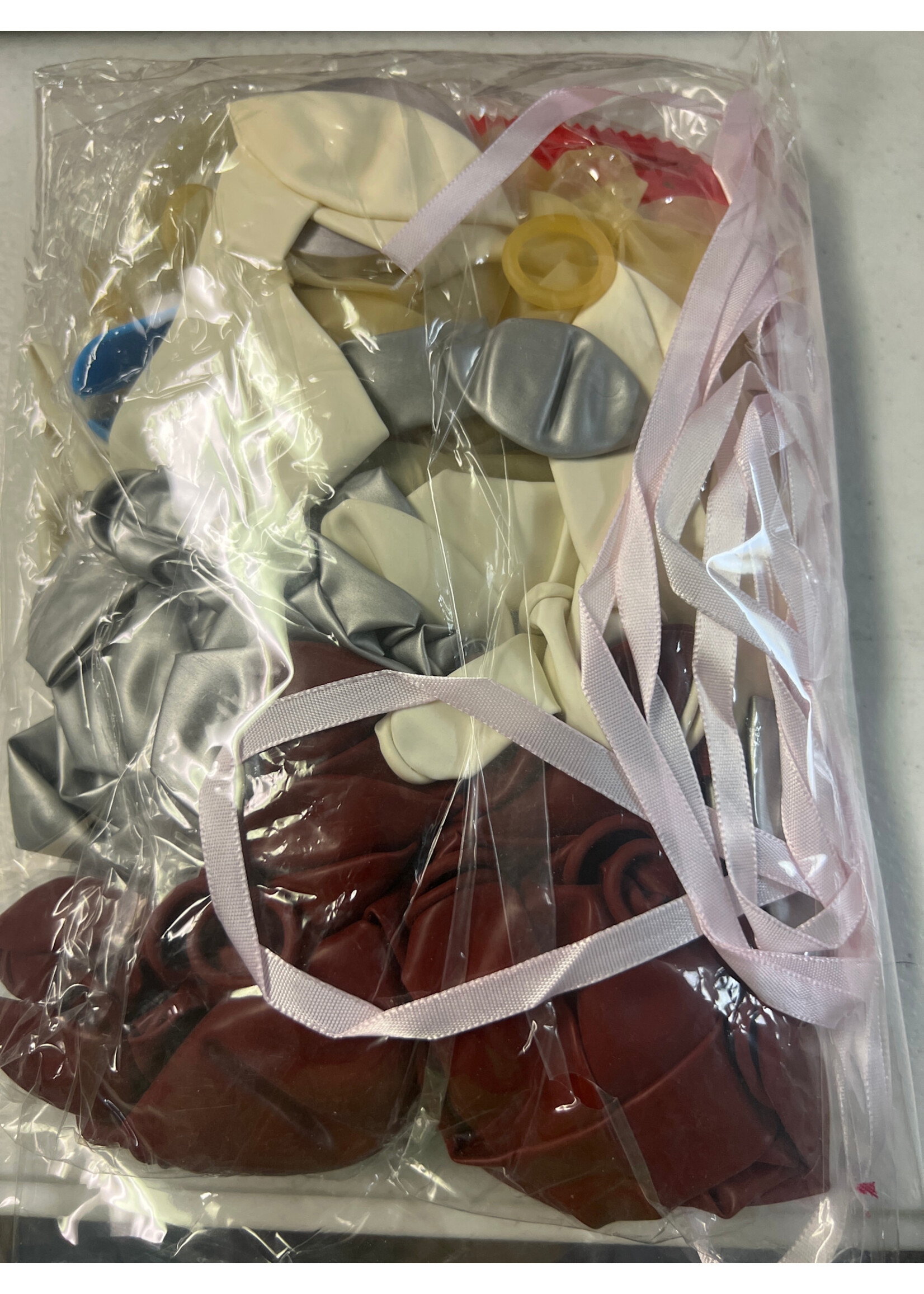 Pack of balloons mostly maroon, some white, gray