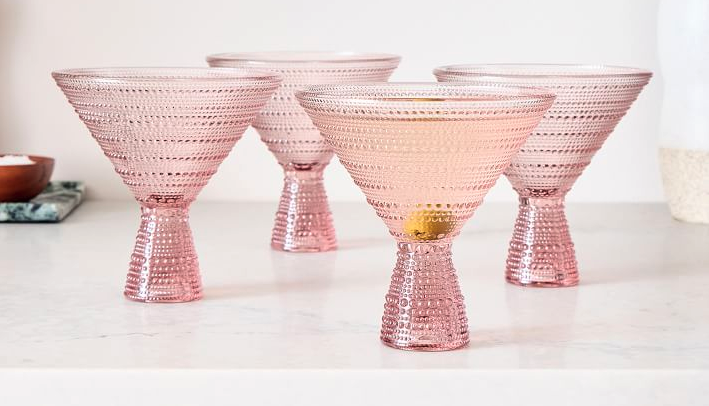 Pink Jupiter martini glasses sit on a white countertop. 