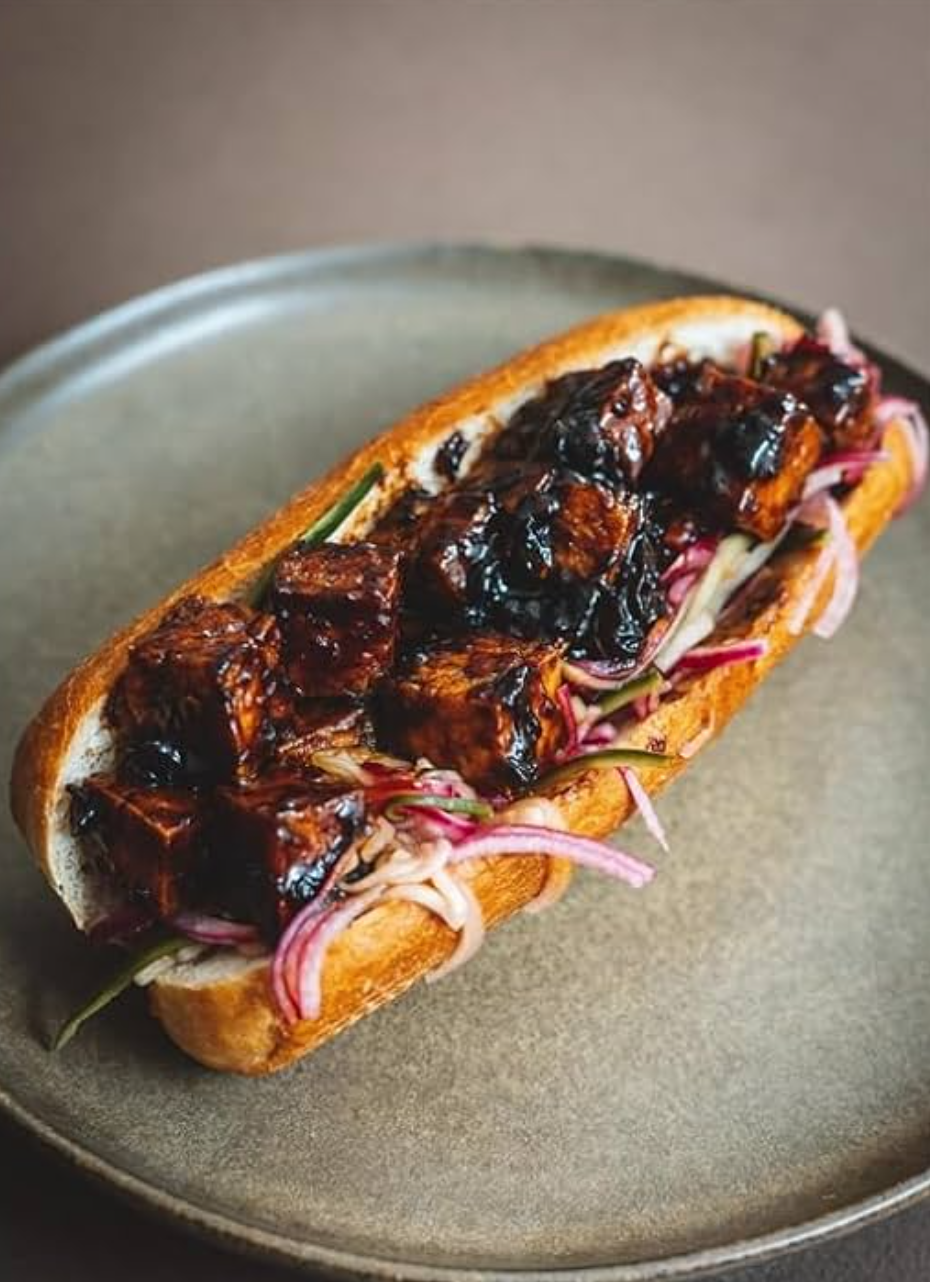 A tofu hoagie sits on a grey plate