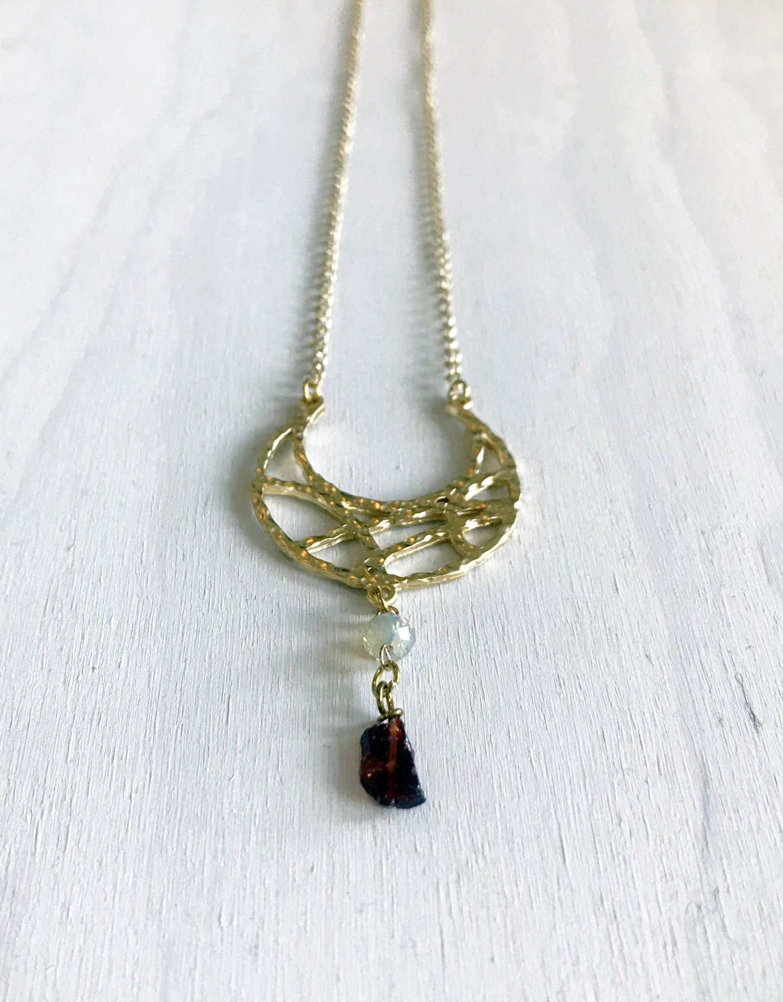 Devil May Wear Wandering Romani Textured Crescent Moon Necklace. Gold Plated pendant. Rough Garnet drop. Swarovski Crystal. Gold plated Chain. 27"