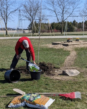 Klomp’s employee planting a tree at a school to support the community and educate students on sustainability. 