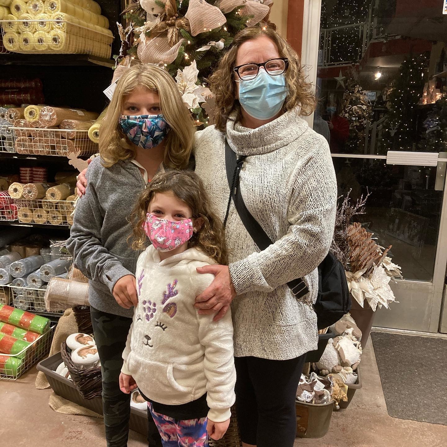 A mother and her two daughters at a Ladies' Night event in the main store, surrounded by holiday decorations.