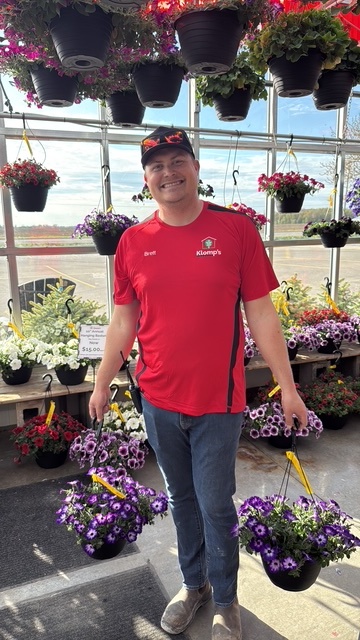 A Klomp’s employee checking on the plants in the greenhouse and taking care of them.