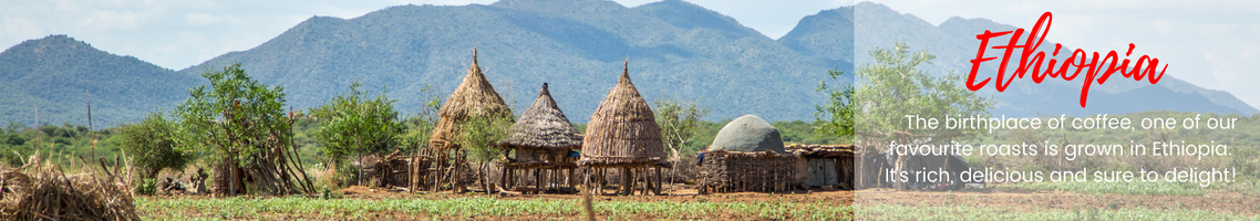 Ethiopia: The birthplace of coffee, one of our favourite roasts is grown in Ethiopia. It's rich, delicious and sure to delight! (Picture features several small thatched buildings with green mountains in the background.)