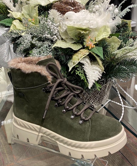 Ara's Montana boots in forest green sit in front of a holiday bouquet