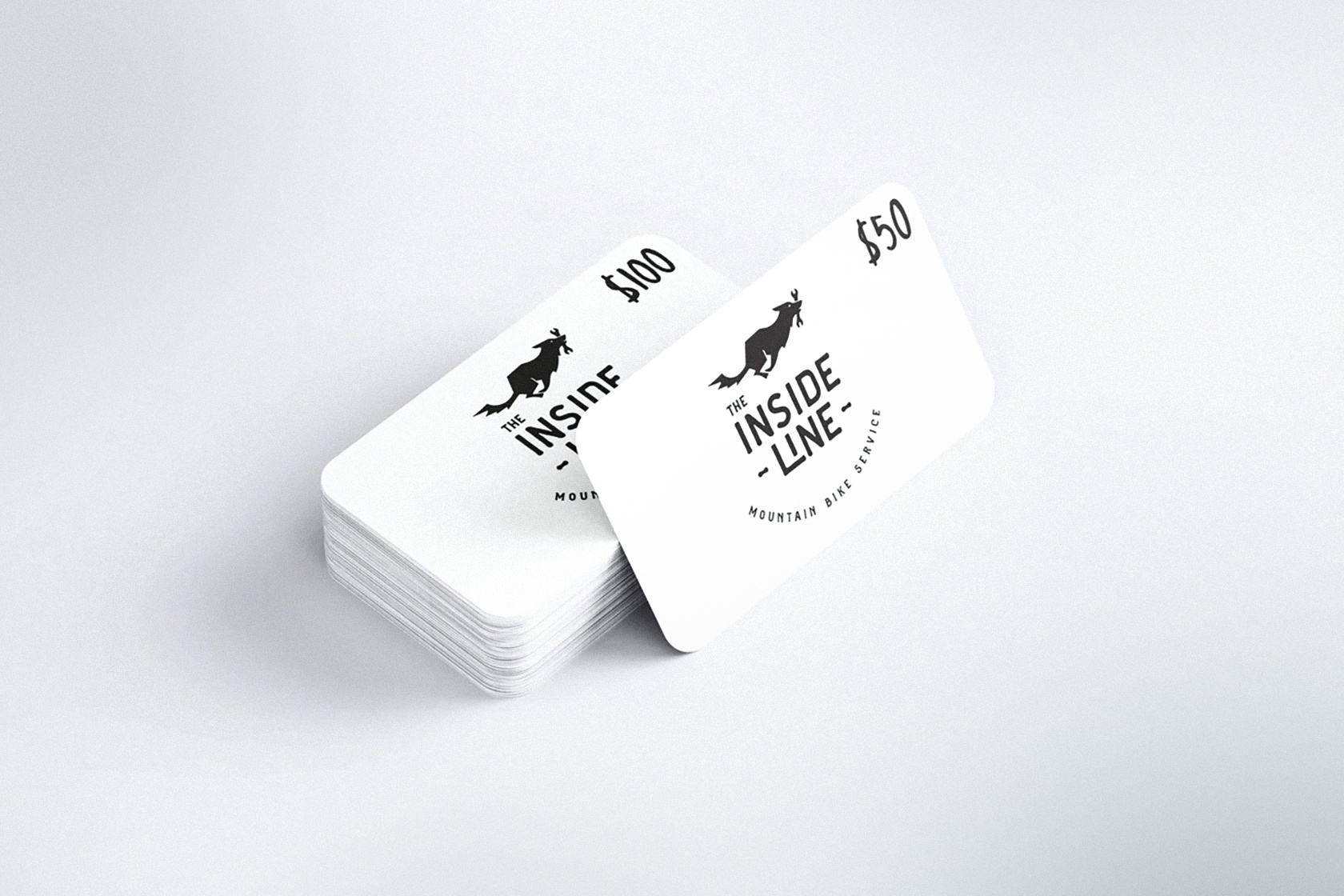 White colored The Inside Line gift cards on a light gray background