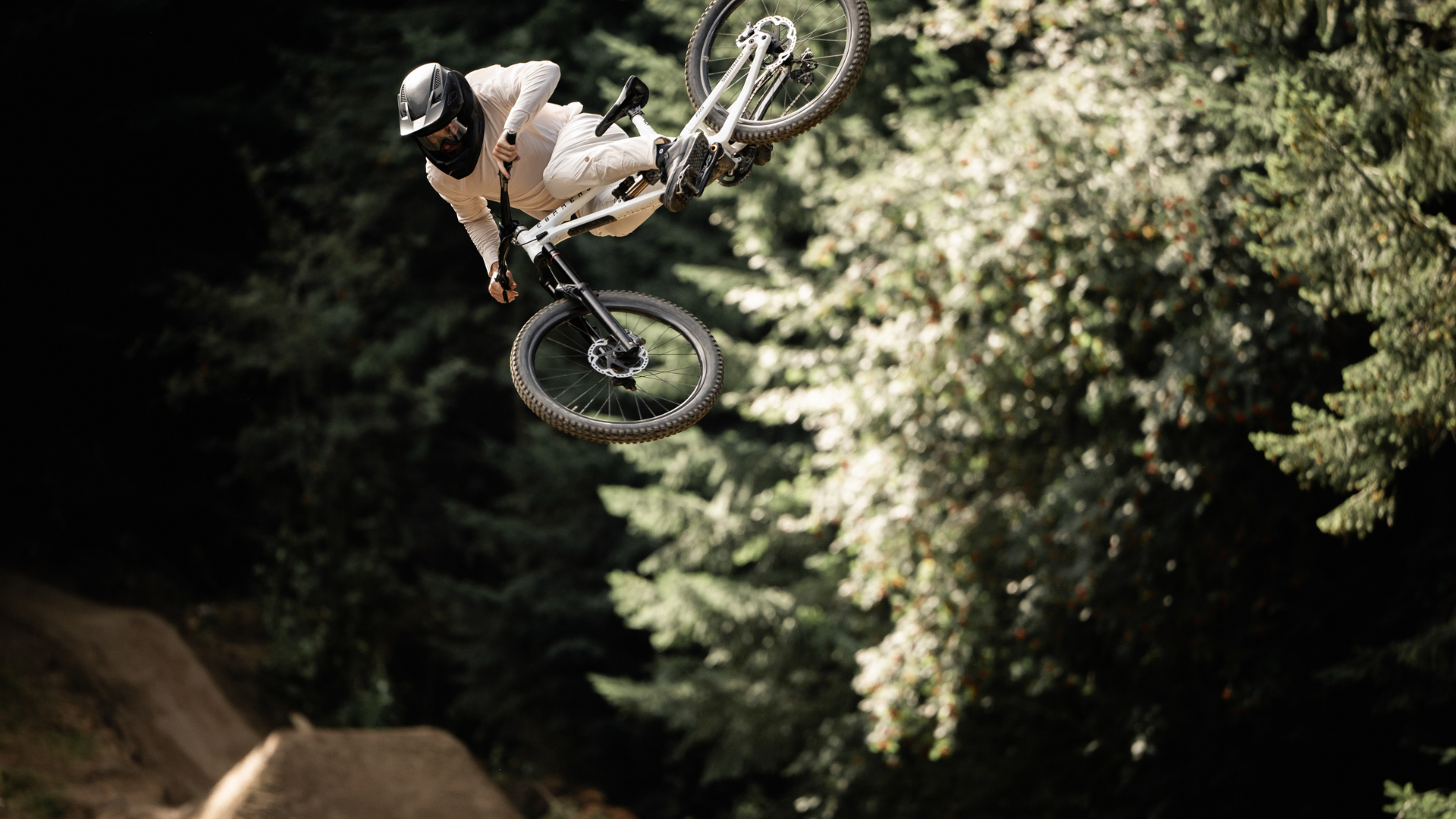Rider decked out in all white Signature apparel kit jumping bike