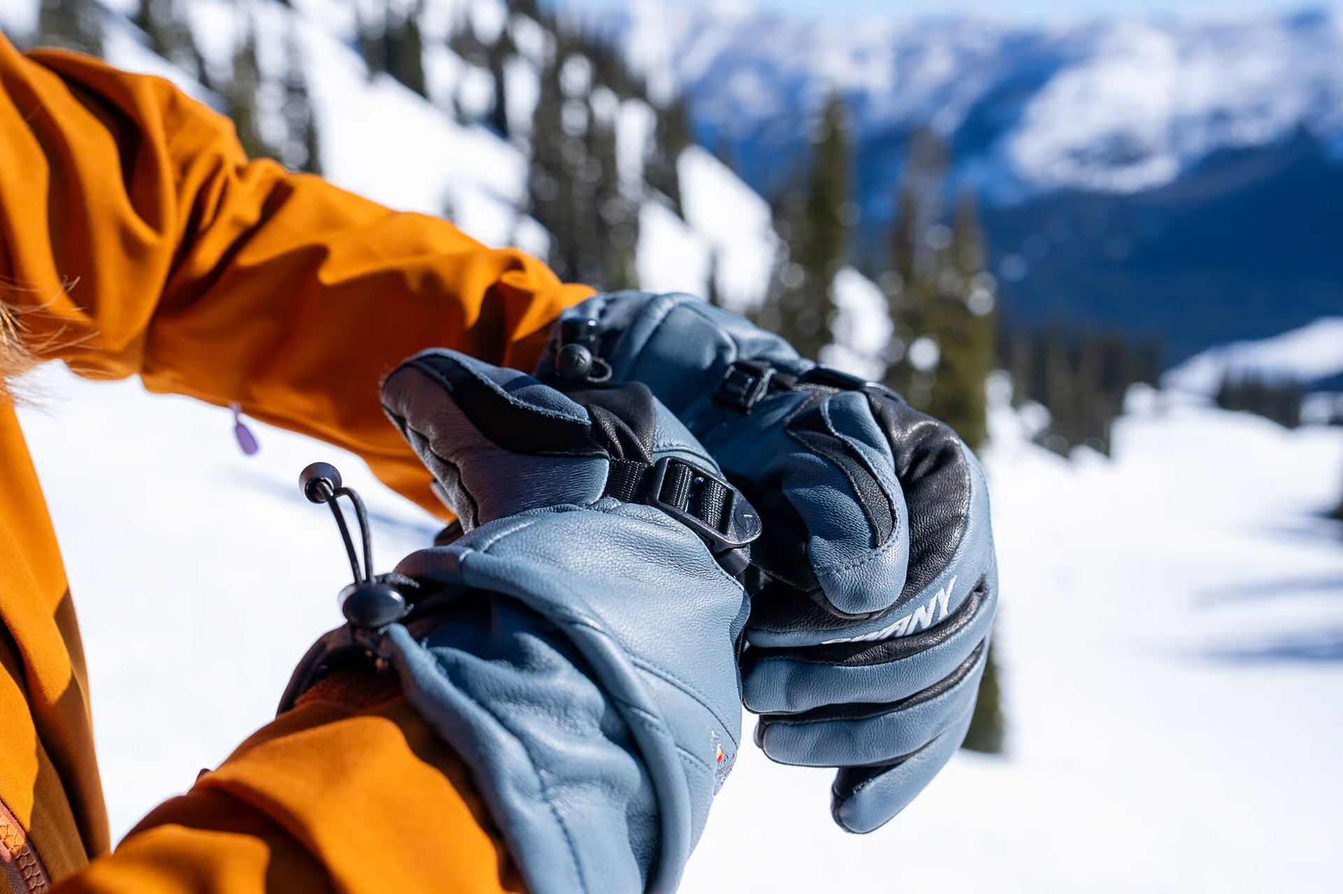 Swany men's ski glove tightening wrist strap while skiing
