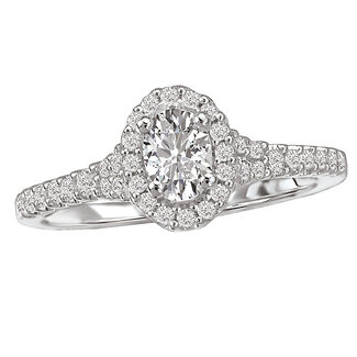 Romance This 14kt white gold engagement ring has diamonds along the shank on either side of an oval shaped halo that surrounds a 6x4mm oval shaped center diamond, (D 3/4 carat total weight, including a 3/8 carat oval center diamond)