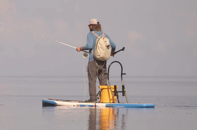 A man is finishing with the BOTE 10'6 HD GATORSHELL paddle board.
