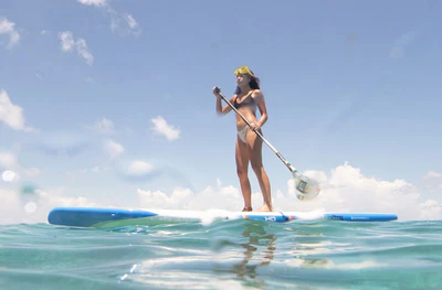 A woman is enjoying her ride with the BOTE 10'6 HD GATORSHELL paddle board.