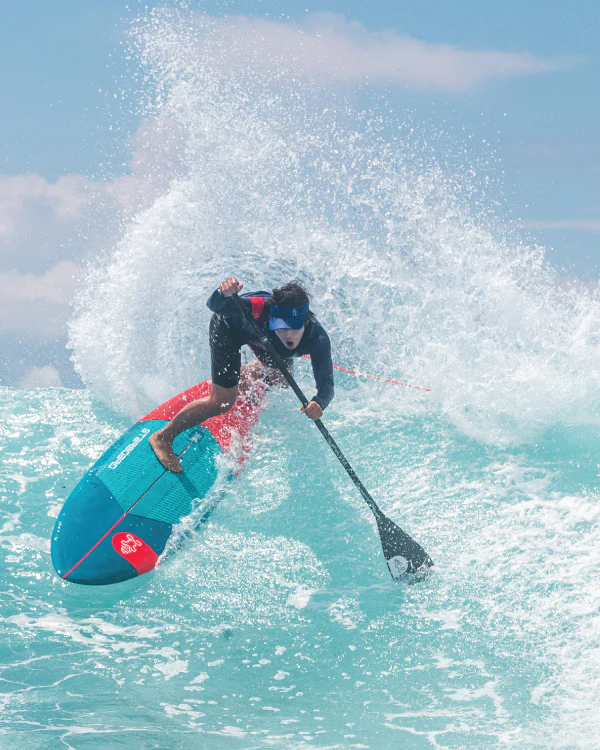 Starboard 7'10" x 28" Pro SUP slashing through a steep turquoise wave with heavy spray