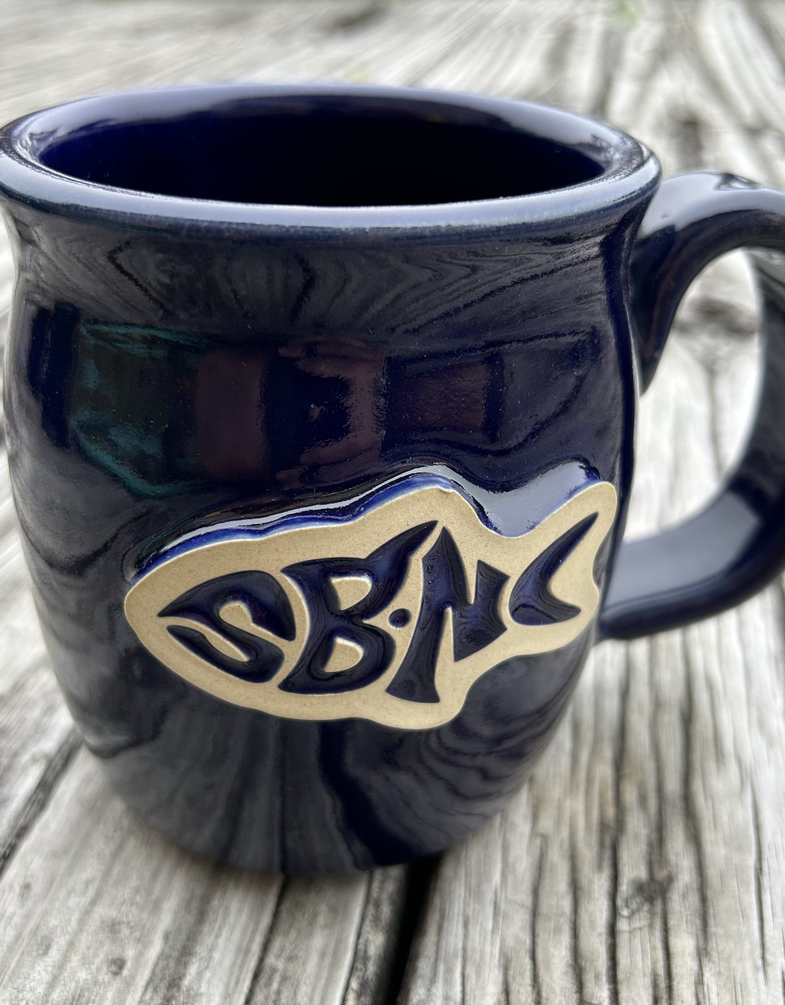 https://cdn.shoplightspeed.com/shops/640525/files/53920195/1600x2048x1/sbnc-fish-logo-sbnc-fish-pottery-mug-royal-blue.jpg