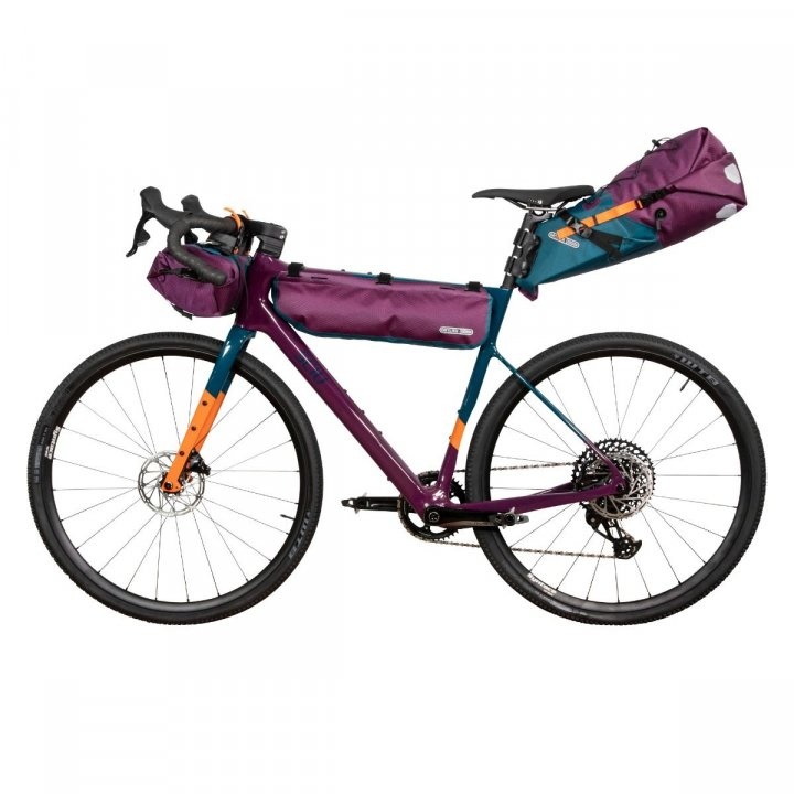 Purple, teal, and orange bikepacking bags, attached to a custom purple teal and orange bike.