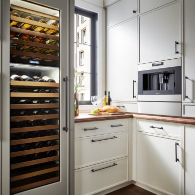 A modern kitchen with the Ellis pulls and a large wine fridge