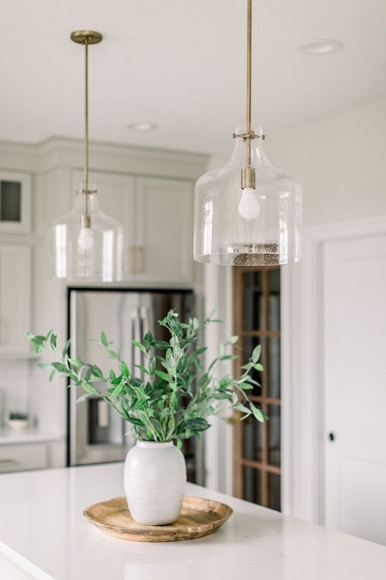 Two glass pendant lights sit above a kitchen island. 