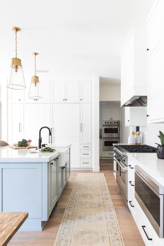 Open bright kitchen with white cabinets and matte black handles and knobs. 