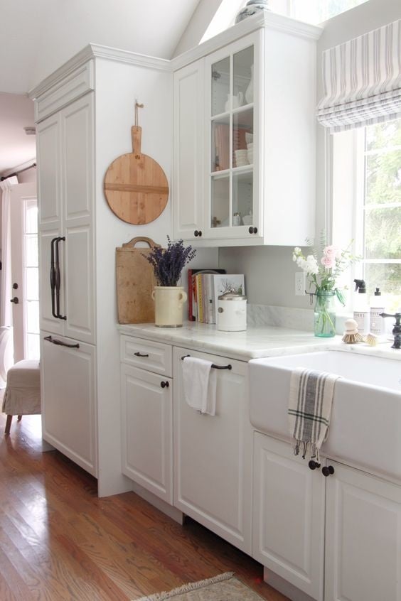 Farmhouse kitchen with paneled fridge with black traditional appliance pulls