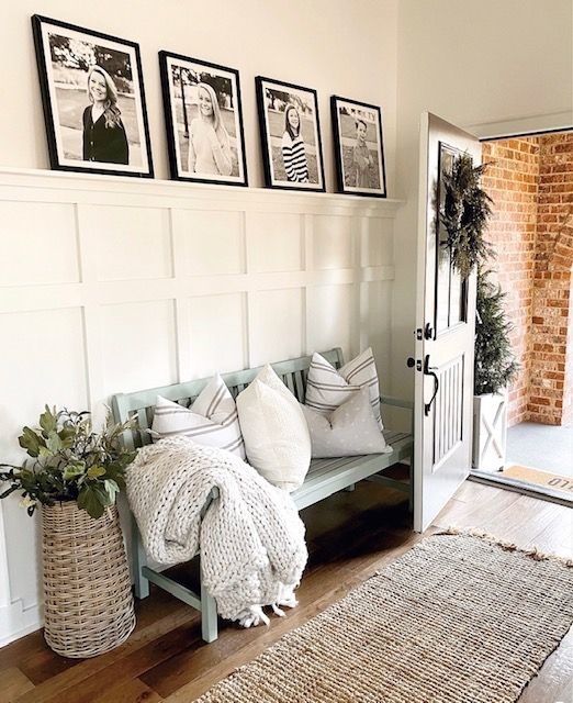 Boot room area with textured accent wall and bench with throw pillows