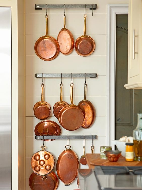 Copper pots and pans hanging on ship lapped wall