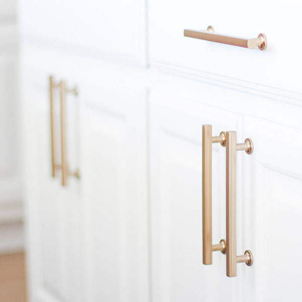 Gold handles on modern white cabinet doors