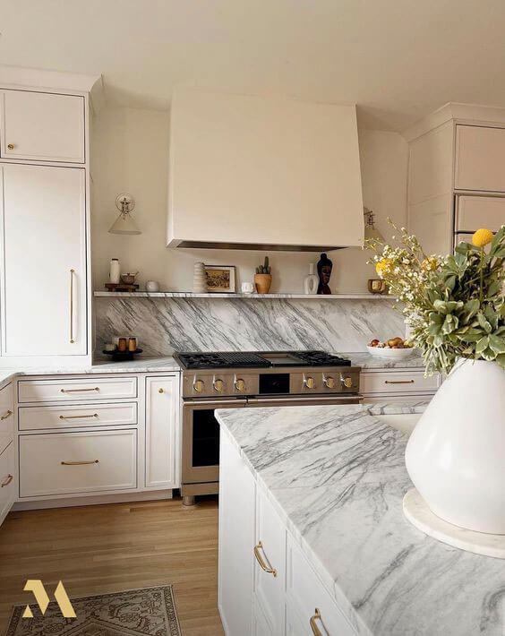 Large range hood with granite kitchen and white cabinetry