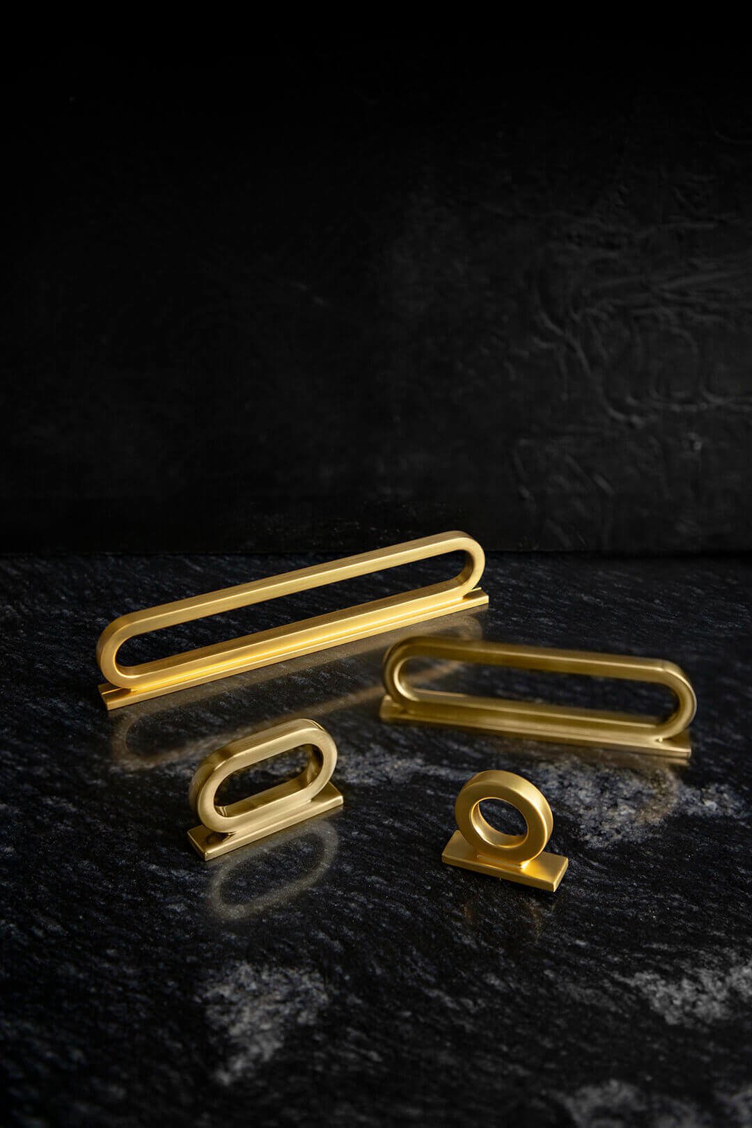 Gold cabinet handles sit against a black marble background