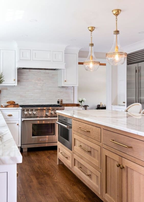 Traditional styled kitchen with two toned cabinetry, gold hardware and two pendant lights