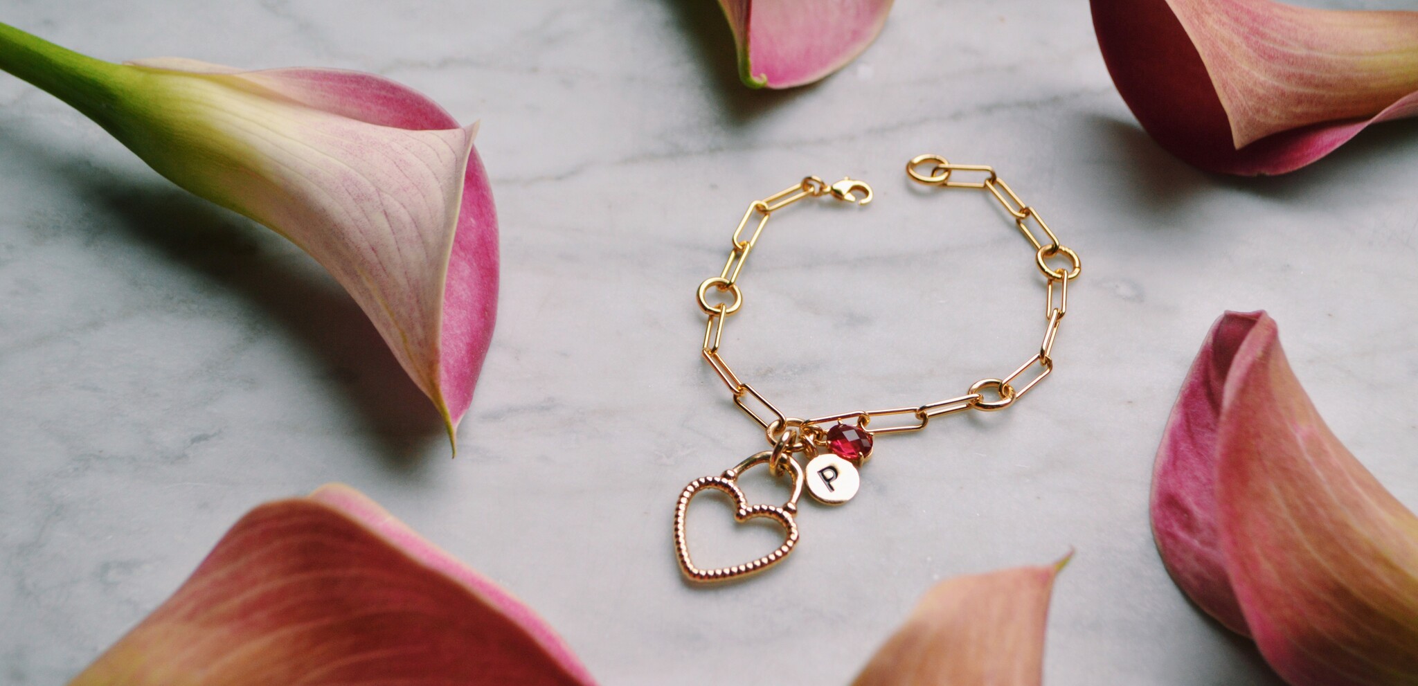 heart charm bracelet surrounded by calla Lillies