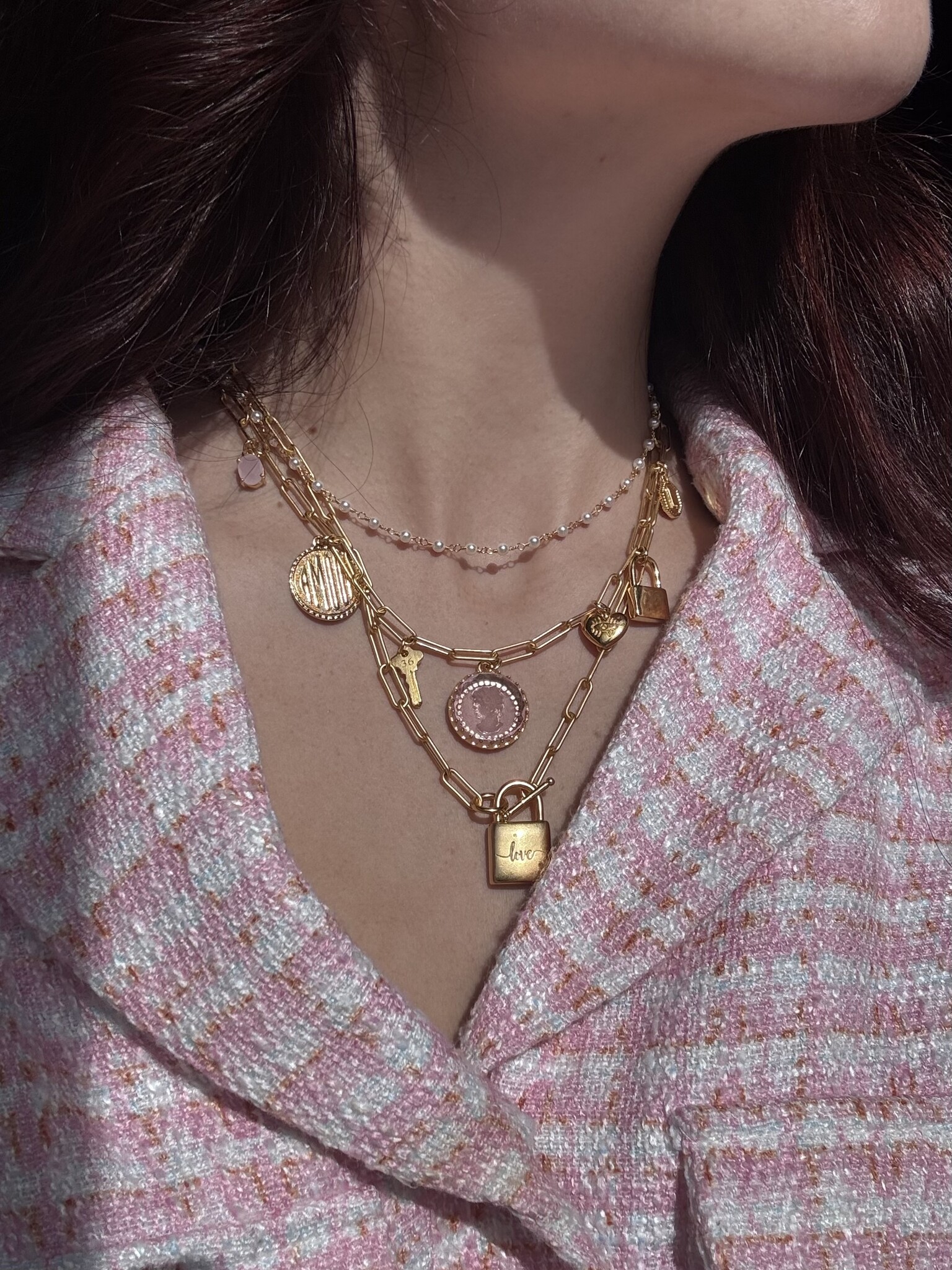 Heart necklaces stacked on model's neck