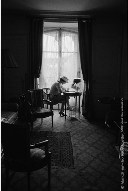 Mark Shaw - Coco Chanel Writes at Desk in Window, Head Down 1957