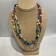 Beverly Creamer BAC 8 - Triple strand multi-color spring mix with new African glass tribal beads, handmade paper beads from Colombia and Guyana, hand-made glass beads from artisans in Hawaii and the Mainland, and connections made from old vinyl records cut into discs in
