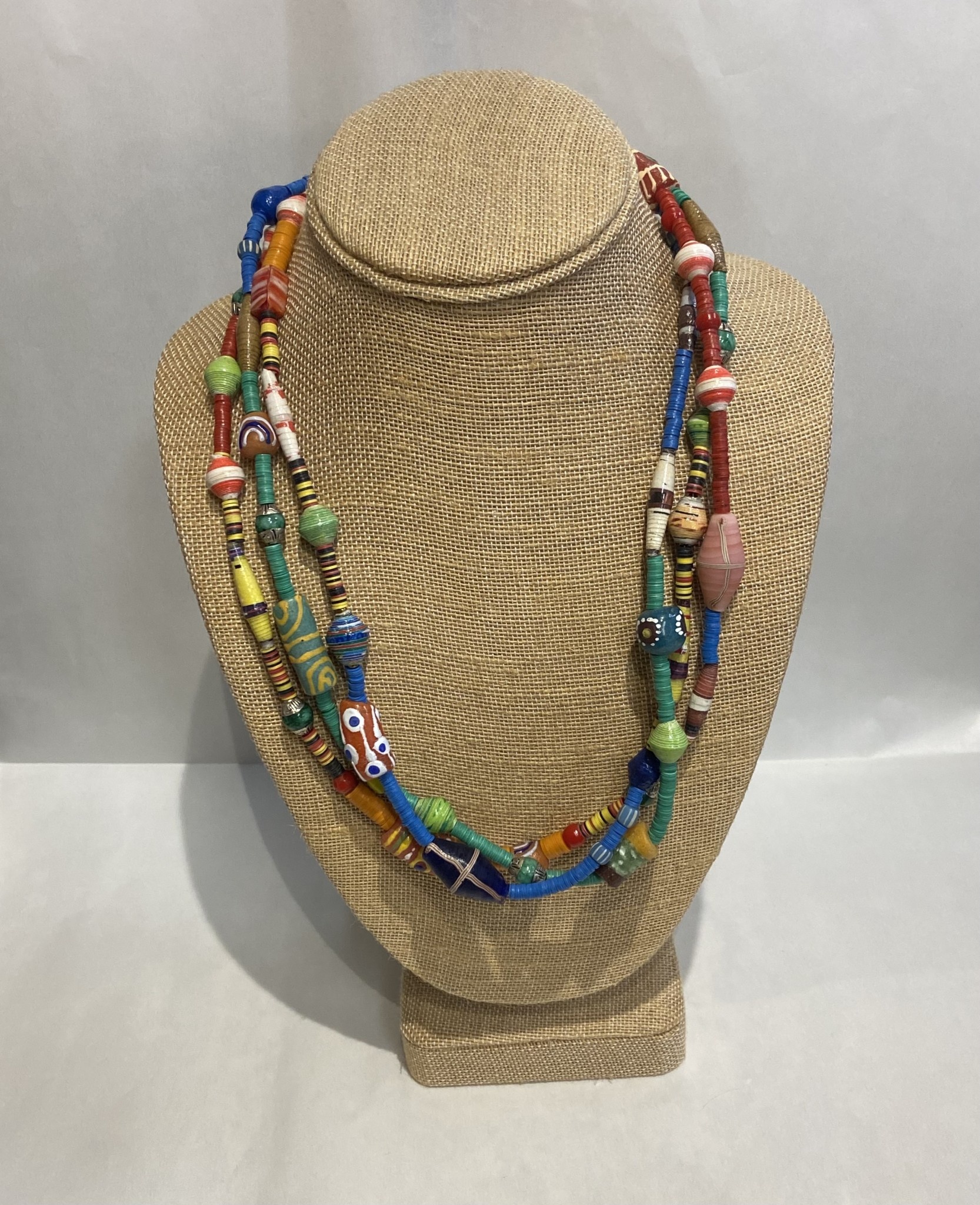 Beverly Creamer BAC 8 - Triple strand multi-color spring mix with new African glass tribal beads, handmade paper beads from Colombia and Guyana, hand-made glass beads from artisans in Hawaii and the Mainland, and connections made from old vinyl records cut into discs in