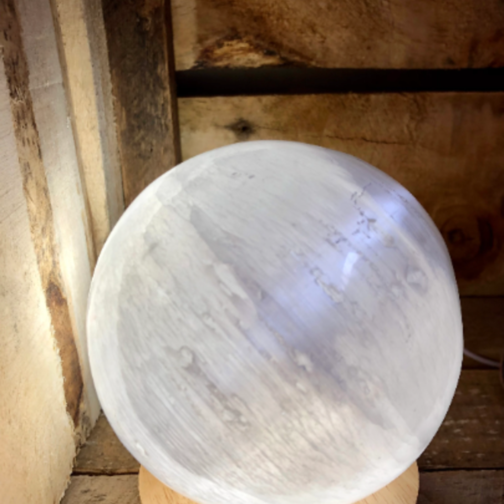 sphère en sélénite, base lumineuse LED disponible dans la boutique, est connue pour agir comme purifiante et chargeante pour vos cristaux